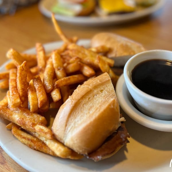 A Mr T's Family Cafe American dip sandwich with fries and a cup of au jus.